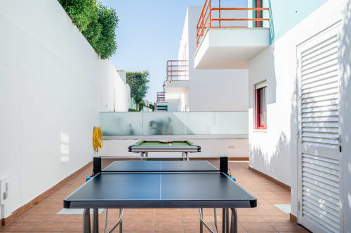 Área de lazer da Villa Odyssey Albufeira com mesas de ping pong e bilhar no terraço