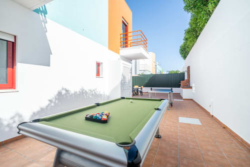 Área de lazer ao ar livre da Villa Odyssey em Albufeira com bilhar, ping pong e zona de descanso