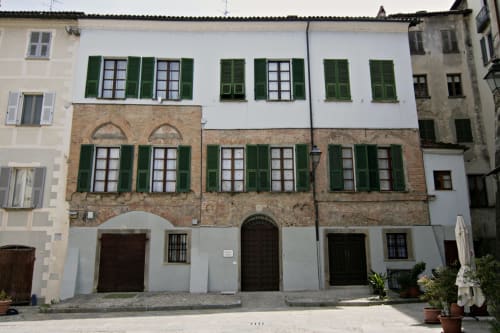 Edificio storico in pietra con persiane verdi a Ceva, Italia - ingresso della Residenza Basiglio B&B