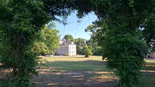 Château de Saint Thomas aperçu à travers une arche de jardin à Saint-Étienne-de-Montluc, France