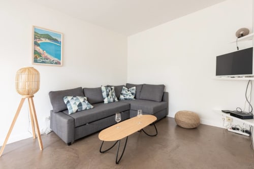 Séjour moderne gris avec décoration côtière, téléviseur écran plat et table en bois à Saint-Cyr-sur-Mer