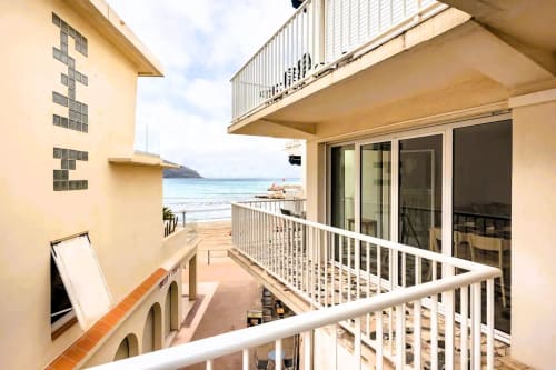 Vue depuis le balcon sur la plage de Saint-Cyr-sur-Mer et la mer Méditerranée, appartement en première ligne avec balustrades blanches