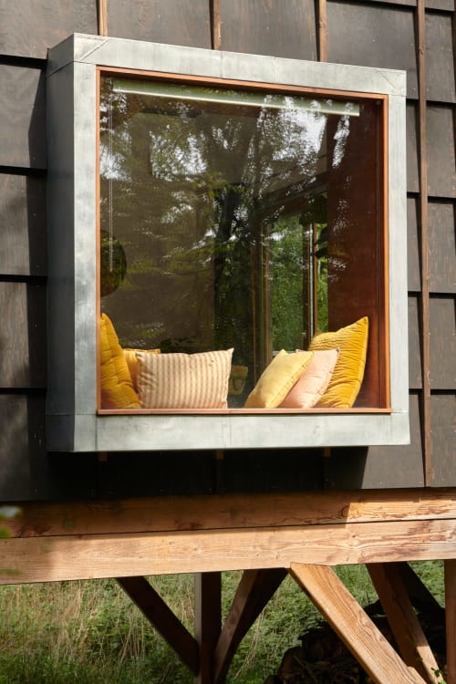 Pod cabane Micro Palace avec coussins jaunes et baie vitrée donnant sur la nature à Vaulx, France
