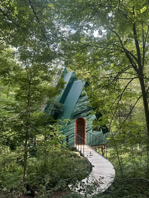 Cabine moderne en A aux lignes géométriques nichée en forêt verdoyante avec passerelle en bois, Micro Palaces Vaulx France
