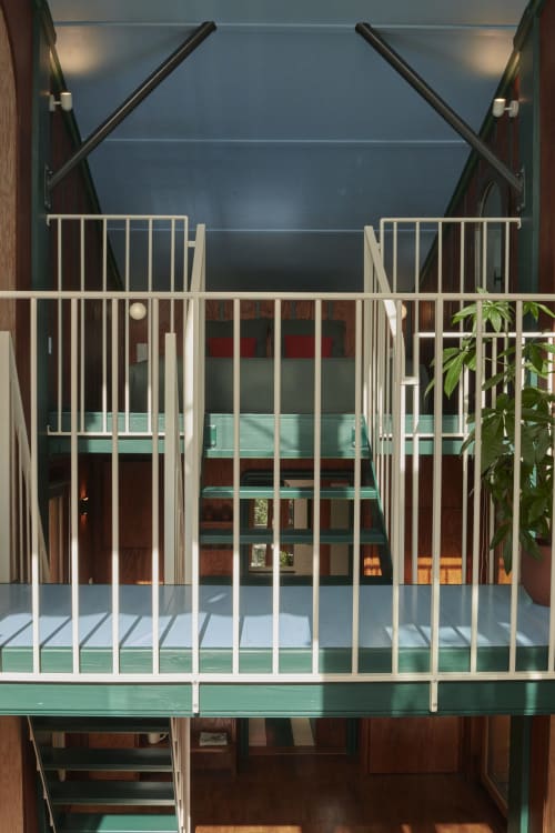 Balustrade blanche avec terrasse verte surplombant la cour intérieure de l'hôtel-boutique Micro Palaces à Vaulx, France