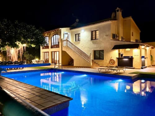 Casa Emilia villa in Moraira with illuminated pool, terrace, and garden views at night