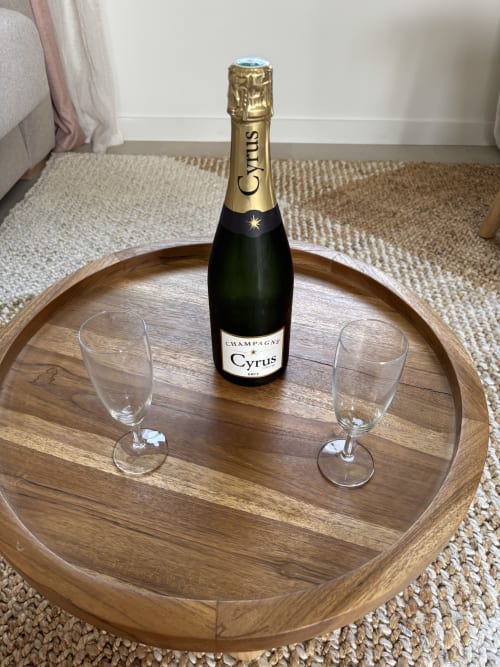 Bouteille de champagne Cyrus avec deux flûtes sur un plateau en bois au Studio Pavin de la Résidence Les 3 Volcans, Clermont-Ferrand