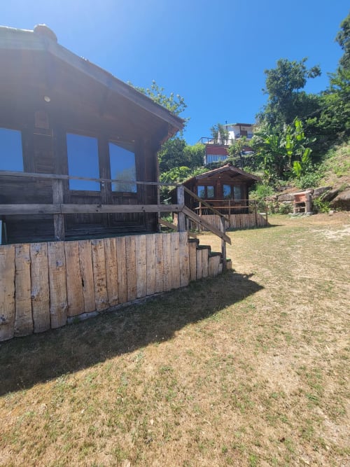 Cabanas rústicas de madeira com vistas para a montanha na Casa do Criado Gerês, aninhada em paisagem verdejante de colinas