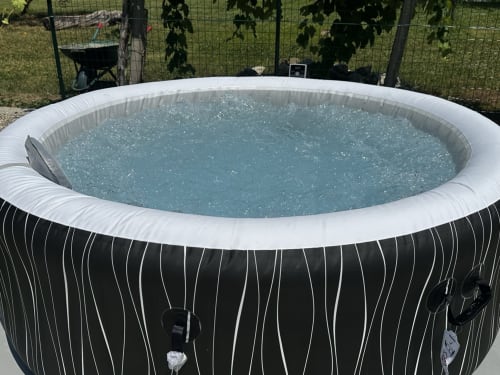 Vasca idromassaggio gonfiabile con acqua turchese nel giardino di Casale Rusignûl, Cassegliano