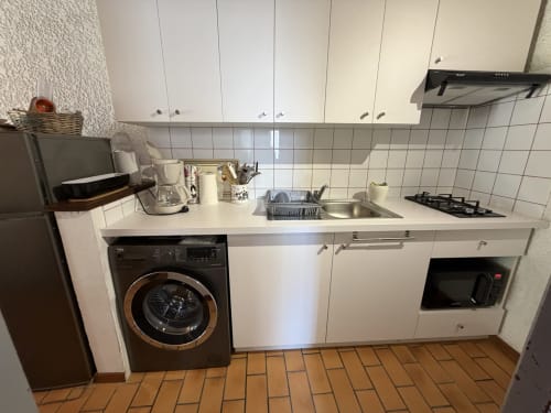 Cuisine moderne à l'appartement Messange à Location Côte Landes avec meubles blancs, évier inox, lave-linge et