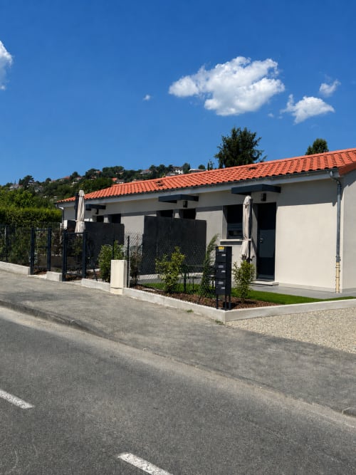 Façade de la Résidence Les 3 Volcans B&B aux murs blancs, toiture en tuiles orangées et pergola noire à Clermont-Ferrand