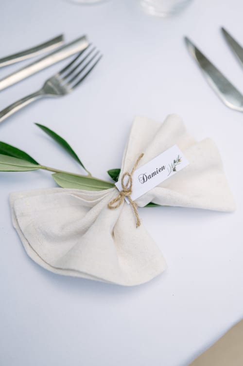 Elegant place setting at Ô Château with white napkin, silverware, and personalized name card at Hayange hotel