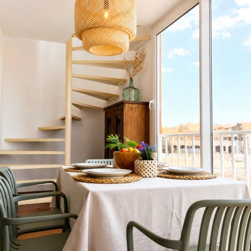 Moderner Essbereich mit Wendeltreppe, gewebtem Pendelleuchte, Balkon mit Meerblick und natürlicher Einrichtung im Sara & Gino