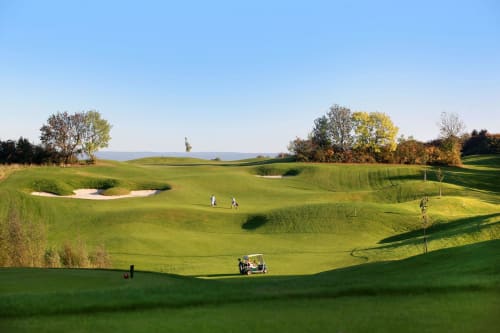 Golf course at Villa Bianca with rolling greens, bunkers, and autumn trees in Mortroux Dalhem, Belgium
