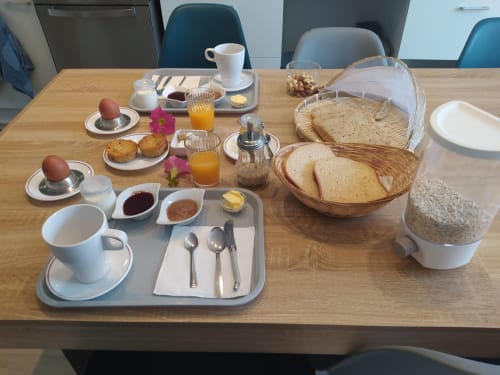 Table du petit-déjeuner à la maison d'hôtes Comme à la maison : œufs mollets, pain grillé, confitures, jus et café à Espéraza