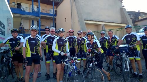 Groupe de cyclistes en maillots fluo à l'Hôtel Du Rocher, Le Caylar, France