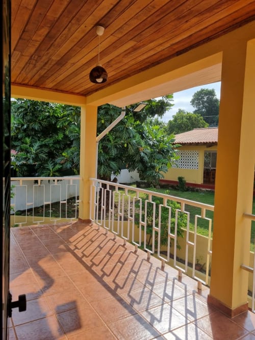 Casa Amarela em São Tomé: aconchegante chalé com terraço amarelo vista para jardim verdejante
