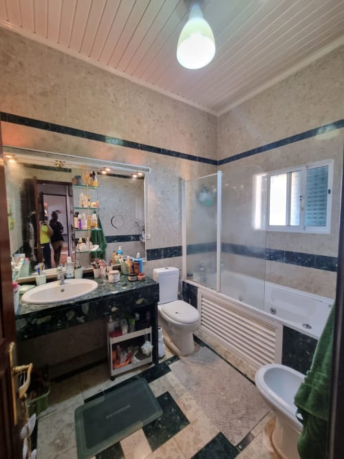 Banheiro moderno na pousada Casa Amarela em Equador Houses, São Tomé, com detalhes em azulejos preto e cinza