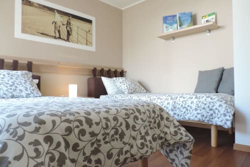 Camere doppie con biancheria a motivi presso Casa Vanzetta B&B a Ziano di Fiemme, arredate con mobili in legno e vista sul giardino