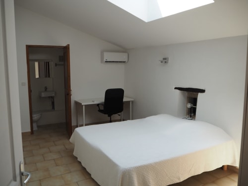 Spacieuse chambre à La Bastide des Princes à Caderousse avec lit, bureau, fauteuil et salle de bain attenante