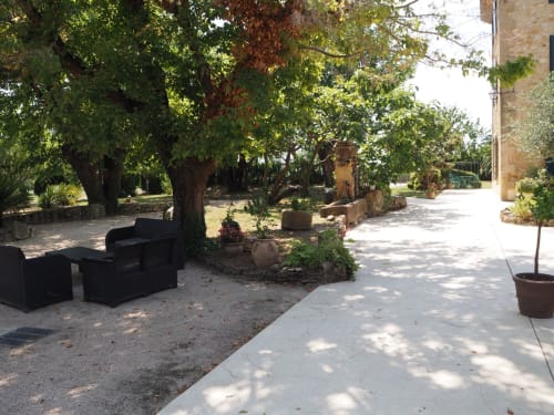 Cour ombragée avec arbres et espaces de détente à La Bastide des Princes, Caderousse