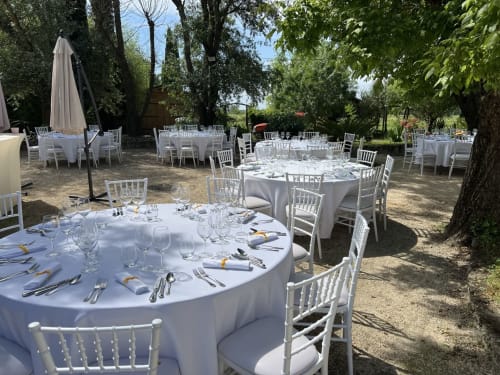 Réception de mariage en plein air à La Bastide des Princes avec tables rondes, chaises Chiavari blanches et décoration élégante