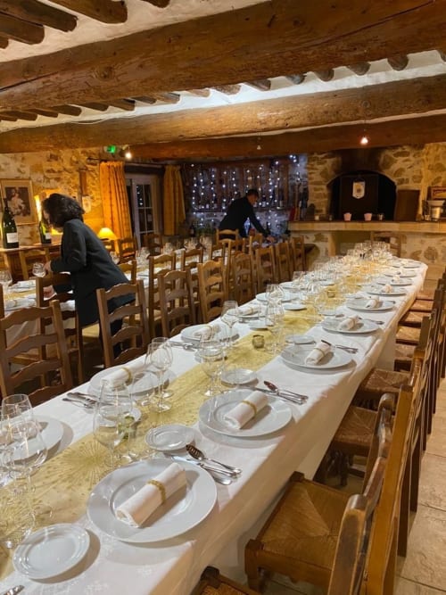 Élégante salle à manger de La Bastide des Princes avec table dressée pour dîner formel, poutres en bois, murs en pierre, Caderousse