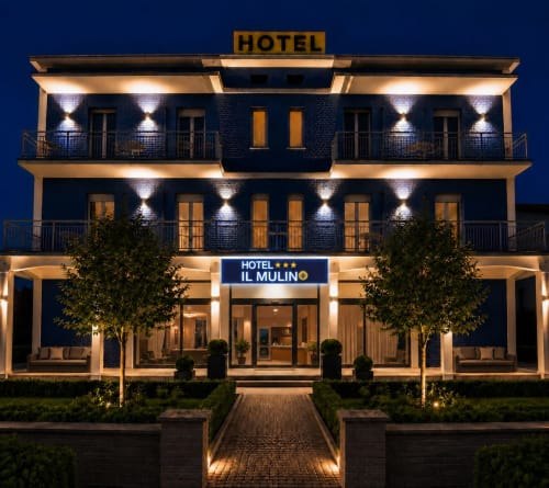 Hotel Il Mulino illuminato di notte a Sassuolo, Italia - edificio in mattoni di tre piani con balconi e illuminazione moderna
