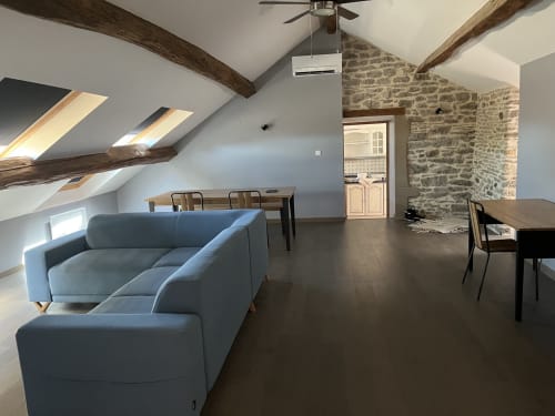 Cottage Mont-Blanc au Saint-Hilaire avec poutres apparentes, canapé bleu, salle à manger et murs en pierre