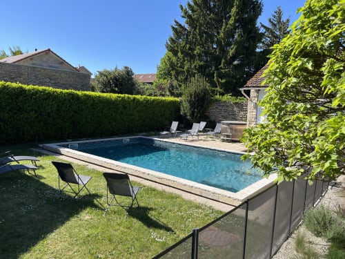Piscine avec chaises longues au gîte Le Saint-Hilaire, Saint-Hilaire-de-Brens, entourée de haies et de verdure