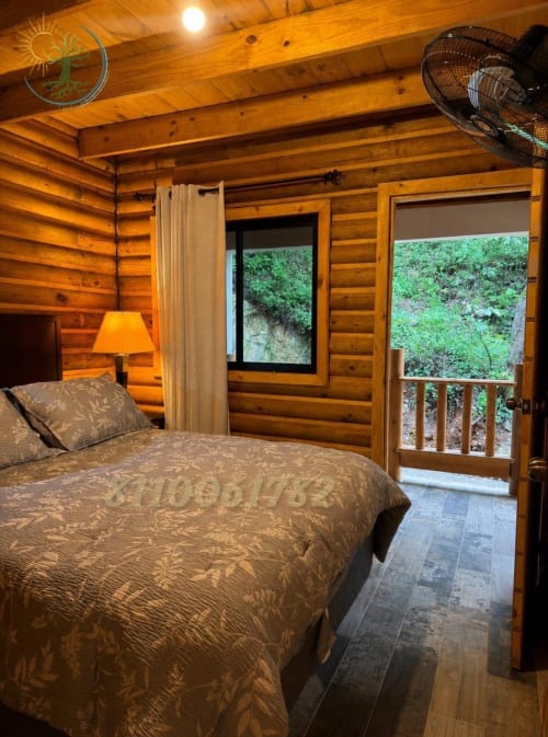 Acogedora habitación de cabaña de madera en Tierra Cielo & SoLuna con cama queen, balcón con vista a montañas y vigas de madera rústica en Potrero de