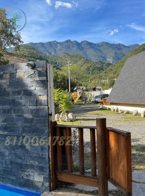 Vista de montaña desde el departamento La Serrana en el hotel Tierra Cielo & SoLuna en Potrero de Serna, México, con muros de piedra y