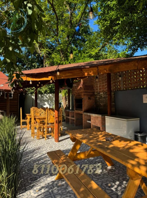 Terraza de madera con área de comedor en Tierra Cielo & SoLuna en Potrero de Serna, México, con mesas de picnic bajo pérgola