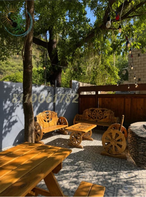 Zona de descanso con asientos tipo carreta de madera en patio sombreado del hotel Tierra Cielo & SoLuna, Potrero de Serna, México