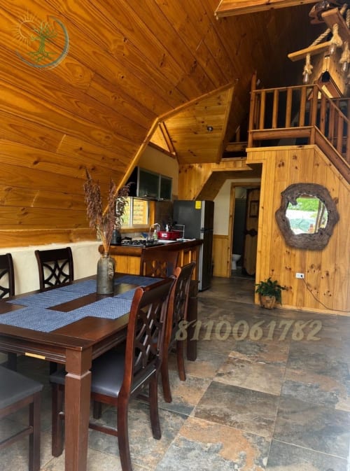 Interior de cabaña de madera en Tierra Cielo & SoLuna con comedor, cocina y vistas a la montaña en Potrero de Serna