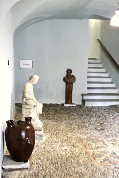 Ingresso di Residenza Basiglio con busti scultorei, vaso ceramico e pavimento in pietra a Ceva, Italia