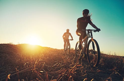 Dos ciclistas en bici al atardecer en un campo cerca de Fuengirola, España