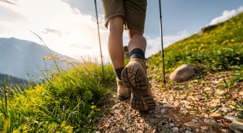 Bota de senderista en sendero montañoso con flores silvestres y valles cerca de Fuengirola, España