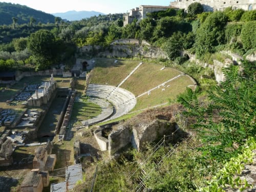 Anfiteatro romano antico del Resort Ponteronico a Sessa Aurunca, circondato da vegetazione lussureggiante e rovine storiche