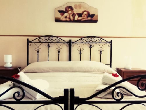 Elegante letto matrimoniale con testata in ferro battuto ornamentale presso Villa Laura B&B a Giardini Naxos, Sicilia