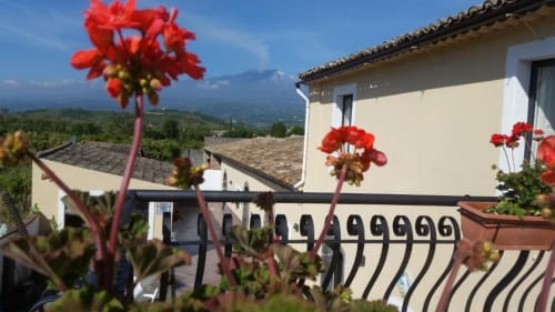 Terrazza Villa Laura B&B con fiori rossi, vista sulle montagne, Giardini Naxos Sicilia