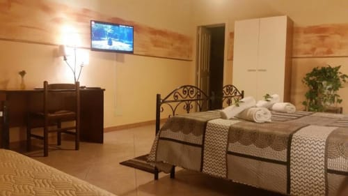 Camera tripla a Villa Laura B&B a Giardini Naxos con letti gemelli, TV, scrivania e vista sul giardino