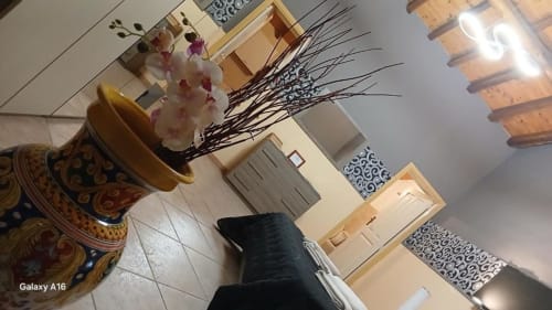 Camera tripla a Villa Laura B&B a Giardini Naxos con vaso decorativo, fiori e arredi in legno