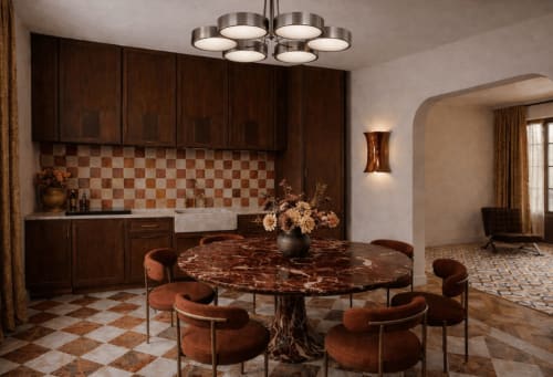 Salle à manger de villa à Deauville avec table ronde en marbre, chaises rembourrées, cuisine en bois foncé et dosseret à carreaux