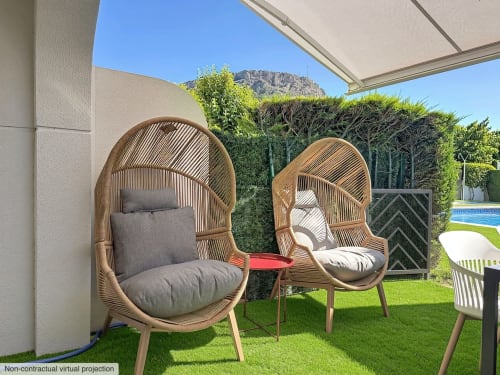 Fauteuils oeufs tissés modernes avec coussins sur la pelouse du gîte d'Estartit, vue piscine et montagnes