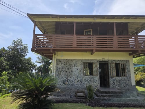 Casa de praia Vila Paraíso no Equador em São Tomé com base de pedra, deck de madeira e jardim tropical