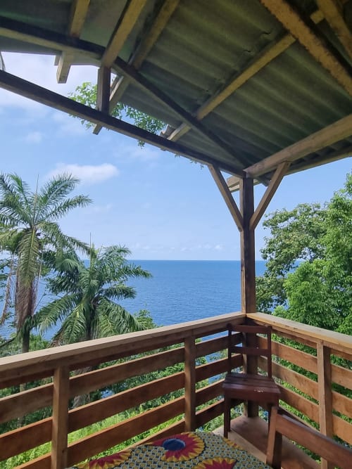 Deck de madeira com vista para o mar em Vila Paraíso, Equador. Casarões em São Tomé com vista para o oceano e palmeiras