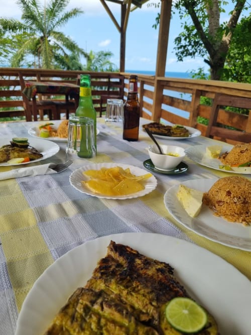 Jantar à beira-mar nas Casas Equador, São Tomé: peixe grelhado, arroz, frutas cítricas e cerveja gelada com vista para o oceano