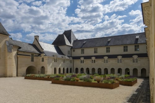 Medieval courtyard at Chateau Haute Roche in Oudon with stone arcades and lavender gardens