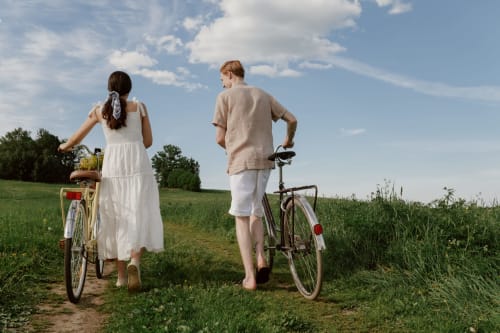 Couple with vintage bicycles on rural path at Chateau Haute Roche, Oudon, France